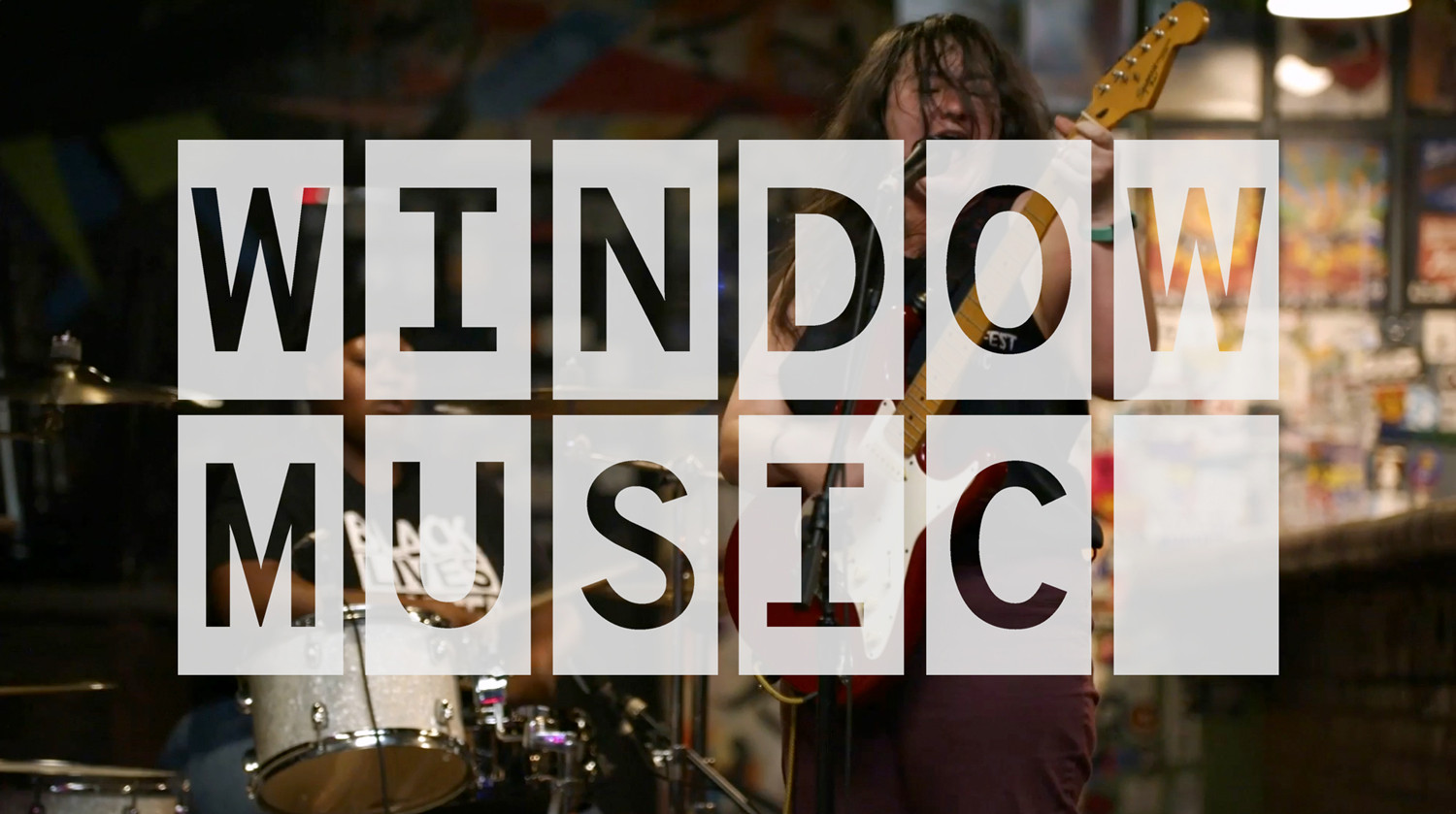 A band is performing in the background of large text that reads ‘Window Music.’
