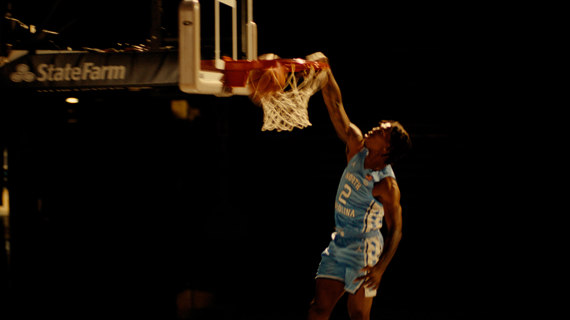 Caleb Love dunking in a UNC jersey