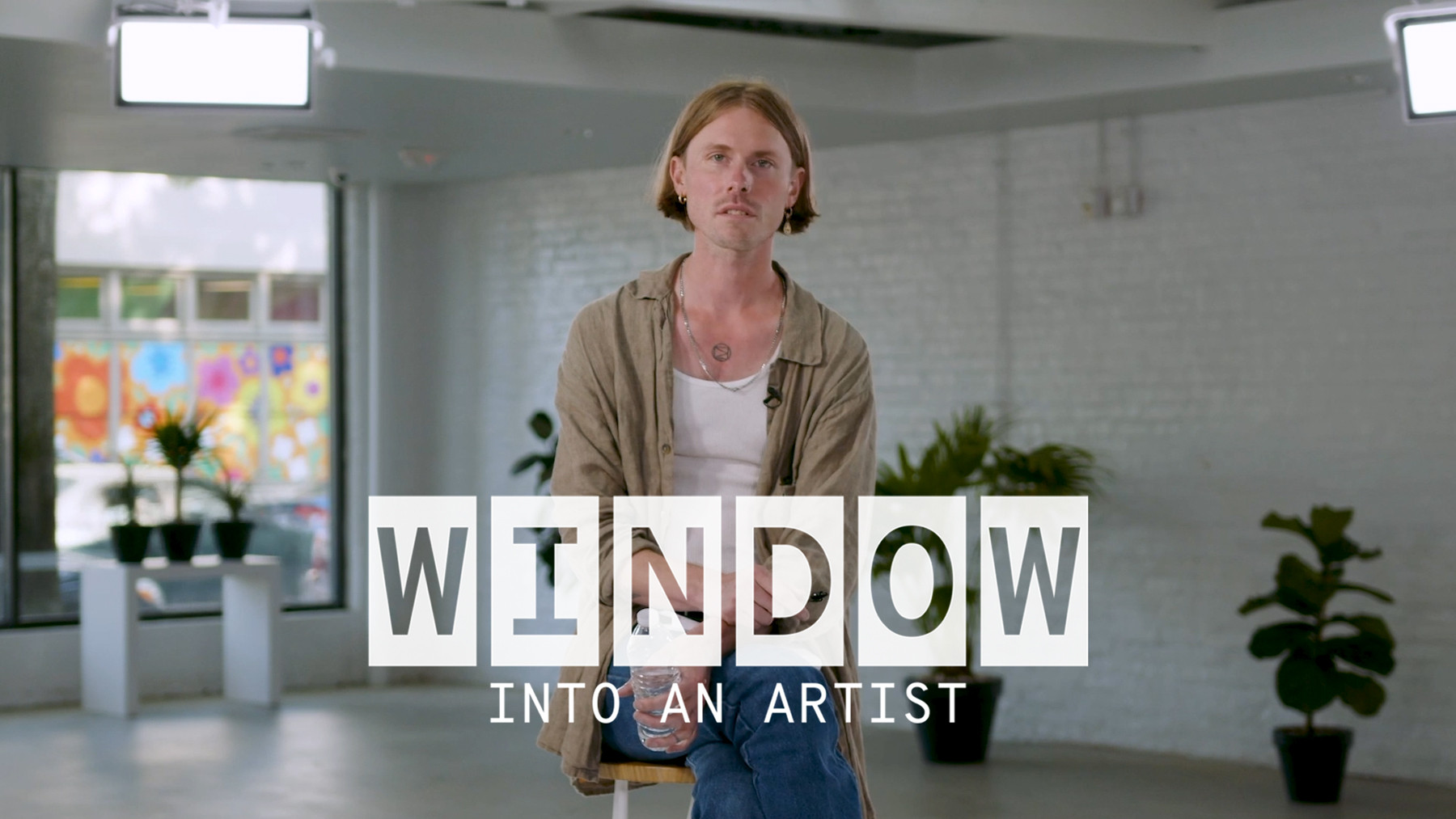 Ryan Gustafson of The Dead Tongues sits on a stool for his interview. Text on image reads ‘Window Into An Artist’. 